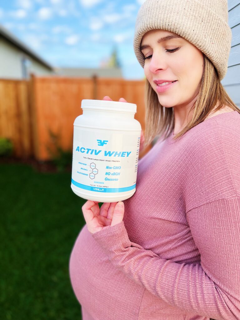 Pregnant woman holding goat whey protein powder